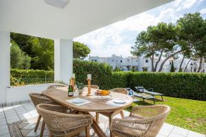 a wooden table and chairs on a patio at Villa Sa Caleta de Cala D'or in Santanyi