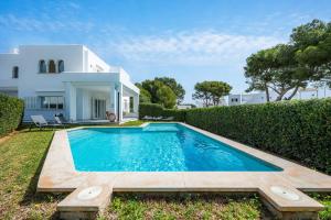 a swimming pool in front of a house at Villa Sa Caleta de Cala D'or in Santanyi