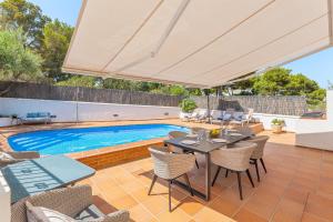 an outdoor patio with a table and chairs and a pool at Ca Na Luisa-Residential Area in Palmanova