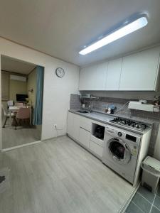 a kitchen with a washing machine and a table at 베델하우스 Bethel House in Seoul