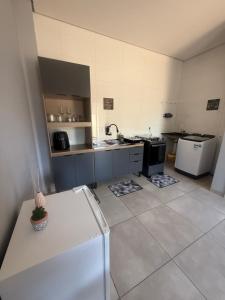 a large kitchen with a refrigerator and a stove at Amazon Loft 09 in Sorriso +9 photos