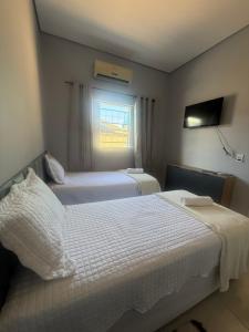 a hotel room with two beds and a window at Amazon Loft 09 in Sorriso