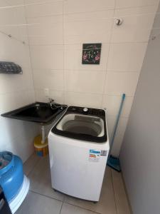 a washing machine in a room with a sink at Amazon Loft 09 in Sorriso