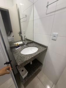 a bathroom with a sink and a mirror at Amazon Loft 09 in Sorriso
