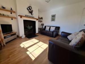 a living room with a couch and a fireplace at Railway Cottage in Conwy