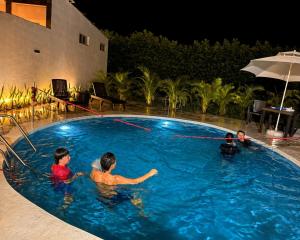 a group of people in a swimming pool at night at Villa Tranquila - Paraíso Privado con Piscina y Amplios Espacios Naturales con Casa Campestre in Ricaurte