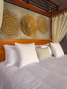 a bed with white pillows and art on the wall at Cardedeu Domos in Álvarez +8 photos