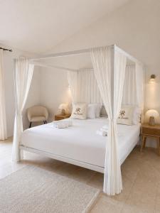 a bedroom with a white bed with a canopy at Pedra Smeralda in Golfo Aranci