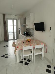 a kitchen with a table and two chairs and a table and a kitchen at Mare D'amare in Porto Cesareo