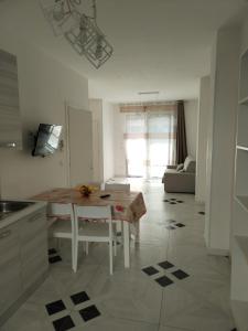 a kitchen and living room with a table and a couch at Mare D'amare in Porto Cesareo