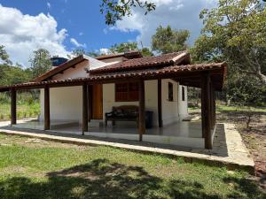 a small house with a thatched roof at Casa Sol Piscina e Cachoeira in Pirenópolis