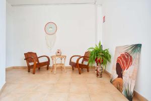 a living room with chairs and a clock on the wall at Résidence Le Lagon in Sainte-Anne