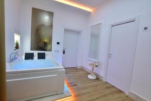 a bathroom with a large tub with a painting on the wall at Domus De Cinti Charme Rooms in Tivoli