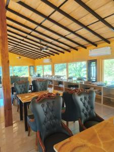 a dining room with tables and chairs and windows at The Corbett Lads in Tota Ām