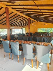 a dining room with a wooden table and blue chairs at The Corbett Lads in Tota Ām +16 photos