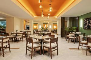 a restaurant with tables and chairs in a room at Fiesta Americana Guadalajara in Guadalajara