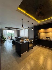a large kitchen with black cabinets and a living room at The Concrete Edit in Benoni