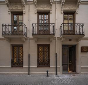 a building with balconies and a fire hydrant on a street at Casa Palacio Taubin in Granada +38 photos