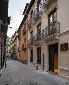 an empty street in a city with buildings at Casa Palacio Taubin in Granada