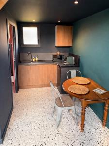 a kitchen with a wooden table and chairs in a room at Chalet in Paluel