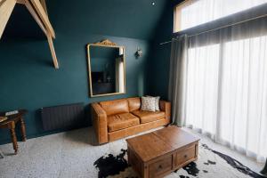 a living room with a leather couch and a mirror at Chalet in Paluel +5 photos