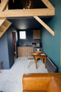a living room with a table and a kitchen at Chalet in Paluel