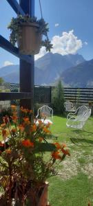 a patio with white chairs and a potted plant at Haven & Hearth in Hunza Valley