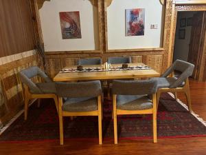 a dining room with a wooden table and chairs at Haven & Hearth in Hunza Valley