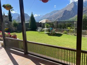 a balcony with a view of a yard with mountains at Haven & Hearth in Hunza Valley