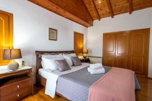 a bedroom with a bed and a wooden ceiling at Kamara House in Tyros