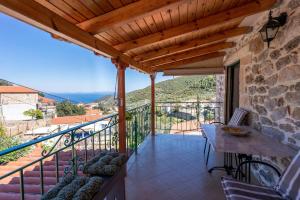 a balcony of a house with a table and chairs at Kamara House in Tyros