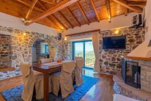 a dining room with a table and a fireplace at Kamara House in Tyros