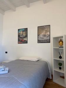 a bedroom with three pictures on the wall and a bed at Brescia Living in Brescia
