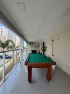 a pool table in a room with a balcony at 7 min de Cabo Frio AP LISBOA in São Pedro da Aldeia