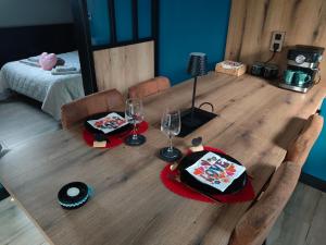 a wooden table with a cake and wine glasses on it at Ô bonheur du paon in Arques