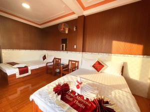 a room with two beds and a table and chairs at Mimosa 2 Hotel - Phan Rang in Phan Rang–Tháp Chàm