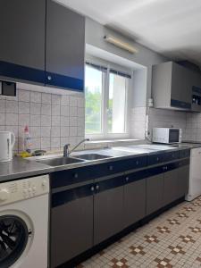 a kitchen with a sink and a washing machine at Déconnection in Saint-Cyr-des-Gâts