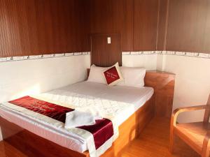 a small bed in a room with a chair at Mimosa 2 Hotel - Phan Rang in Phan Rang–Tháp Chàm