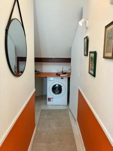 a hallway with a washing machine and a mirror at LA Petite ferme 1 in Saint-Maur-des-Fossés
