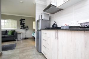 a kitchen with a counter top and a living room at Scheunberg 4 Modern 1 Bedroom Flat in Centurion +5 photos