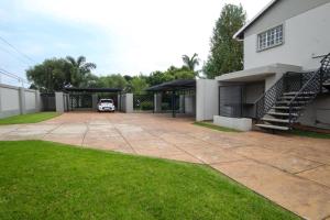 a car parked in a garage next to a house at Scheunberg 4 Modern 1 Bedroom Flat in Centurion