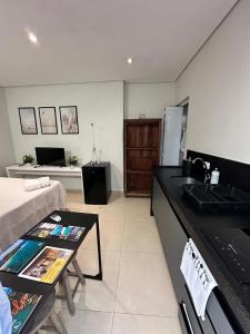 a kitchen with a sink and a living room at Studio Matriz 1 e 2 in São Sebastião