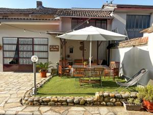a patio with an umbrella and a table and chairs at AMY B&B - Casetta di Charme in Vercelli
