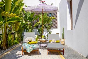 a patio with two chairs and an umbrella at White Memories boutique home - Romantic Stay in Afandou in Afantou