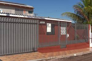 a metal fence with a red door on a street at Kitnet confortável in Foz do Iguaçu