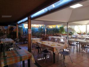 an empty restaurant with tables and chairs and umbrellas at Camping Roma in Ventimiglia
