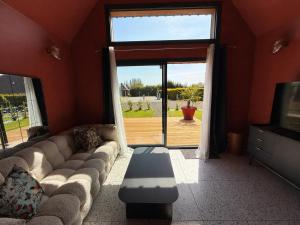 a living room with a couch and a large window at Tiny Chalet in Paluel