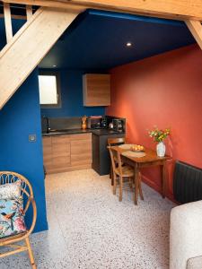 a kitchen with a table and a blue wall at Tiny Chalet in Paluel