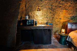 a bathroom with a sink and a bed in a cave at La Voûte Etoilée in Doué-la-Fontaine