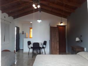 a bedroom with a bed and a table and chairs at Departamentos Algarrobo in Arroyo de Los Patos +11 photos